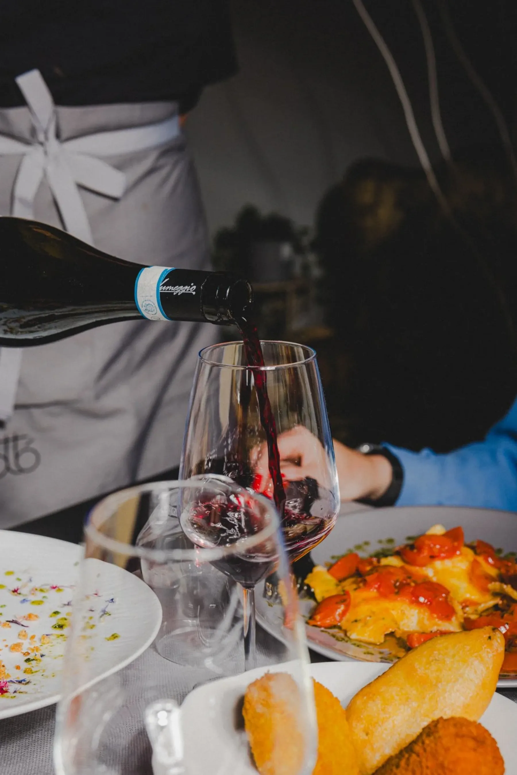 Vino rosso versato al tavolo accanto ai fritti