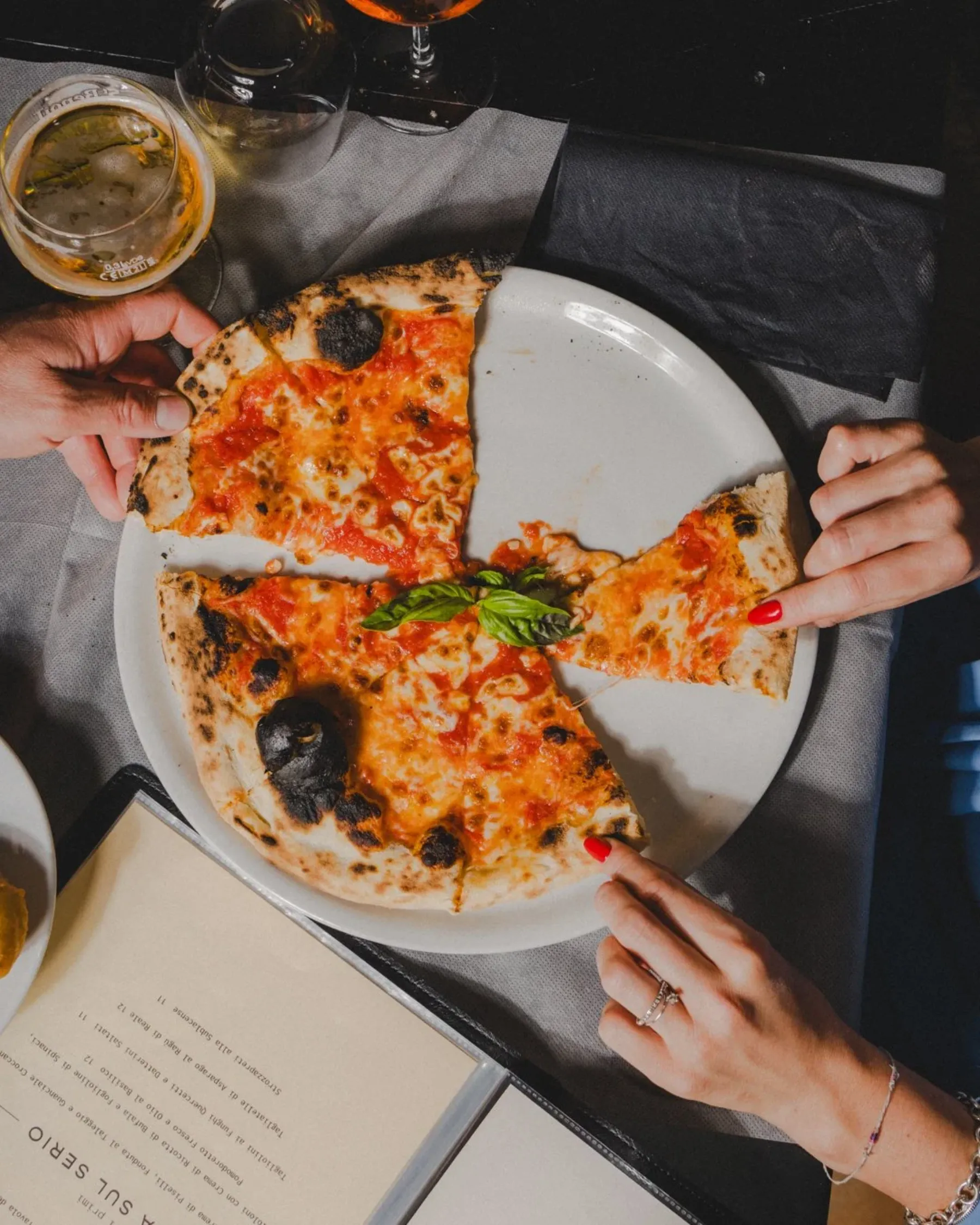 Pizza da condividere e birra al tavolo