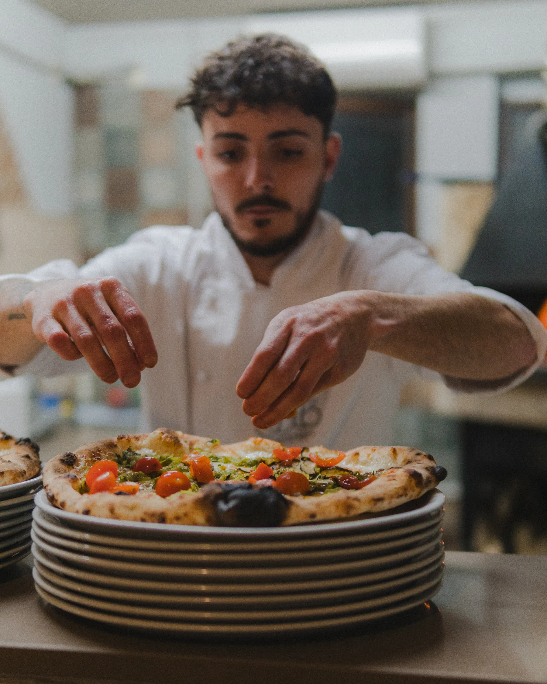 Gli ultimi tocchi sulla pizza appena sfornata