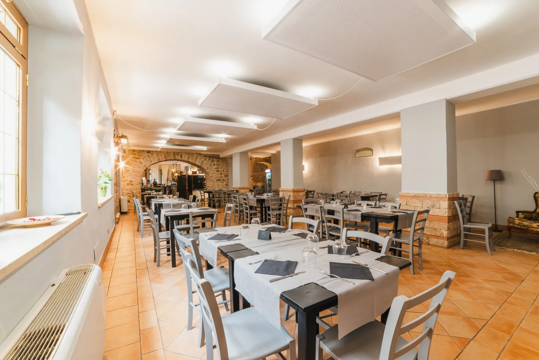 La sala del ristorante Da Bottò con l'arco in pietra